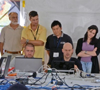 Attendees gathered around laptops inside a large tent.