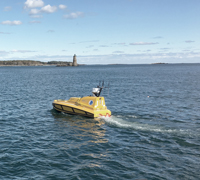 ASV cruising with lighthouse in the background.