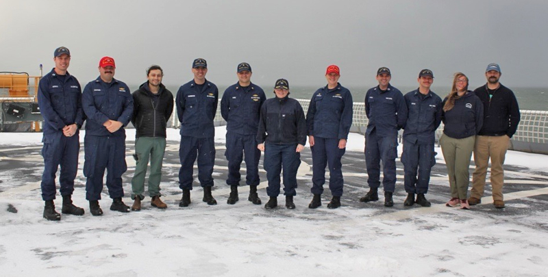 Members of Healy command and the science team pose on the snowy deck of the Healy.