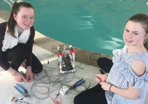 Two girls with their SeaPerch poolside