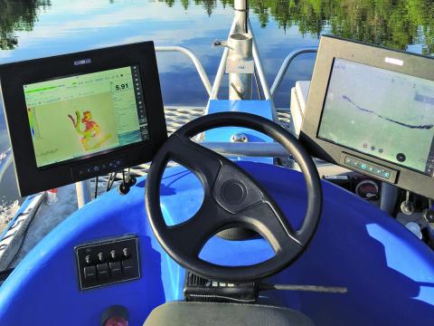 Photo of the Zego Boat's console with steering wheel and drual monitors.